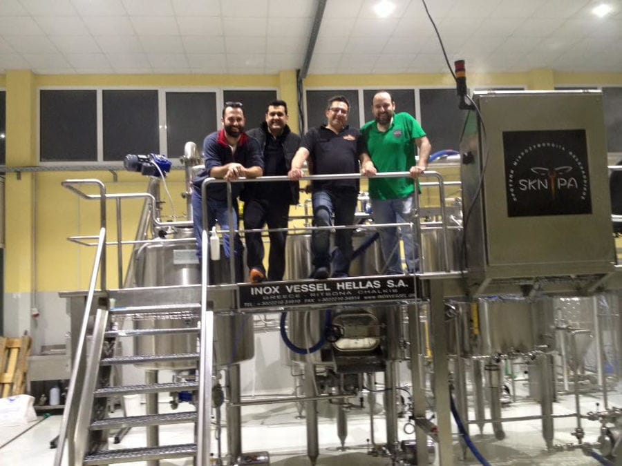 four men smiling happily at the camera at 'Sknipa' plant